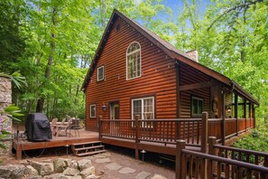A log cabin with a deck, surrounded by trees. - Iron Mountain Lodge 3 Bedroom Cabin by RedAwning (Butler)