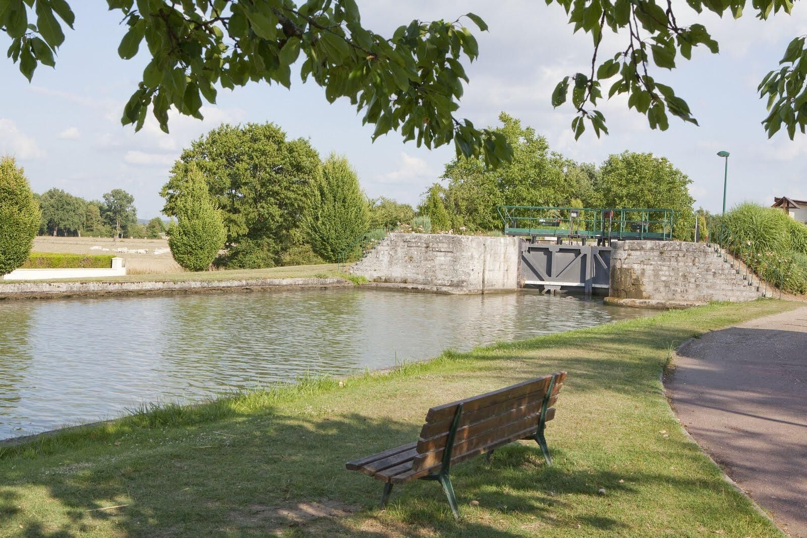 Un parc amb una panxa, un canal i un pont.