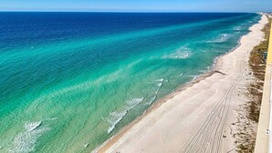 Ein Küstenstrand mit klarem, türkisfarbenem Wasser und einem Sandstrand.