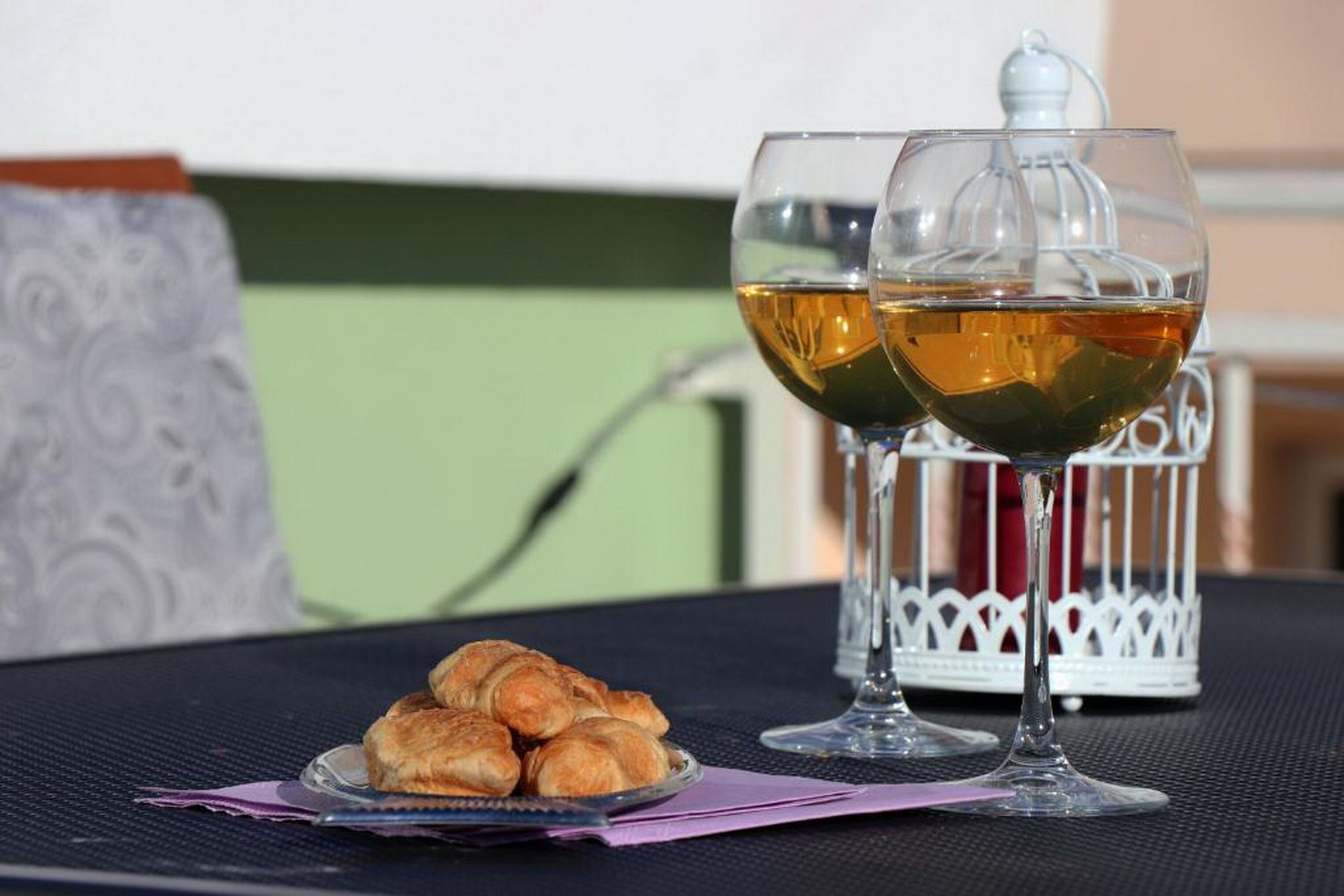 Two glasses of tea on a table with a tray of croissants.