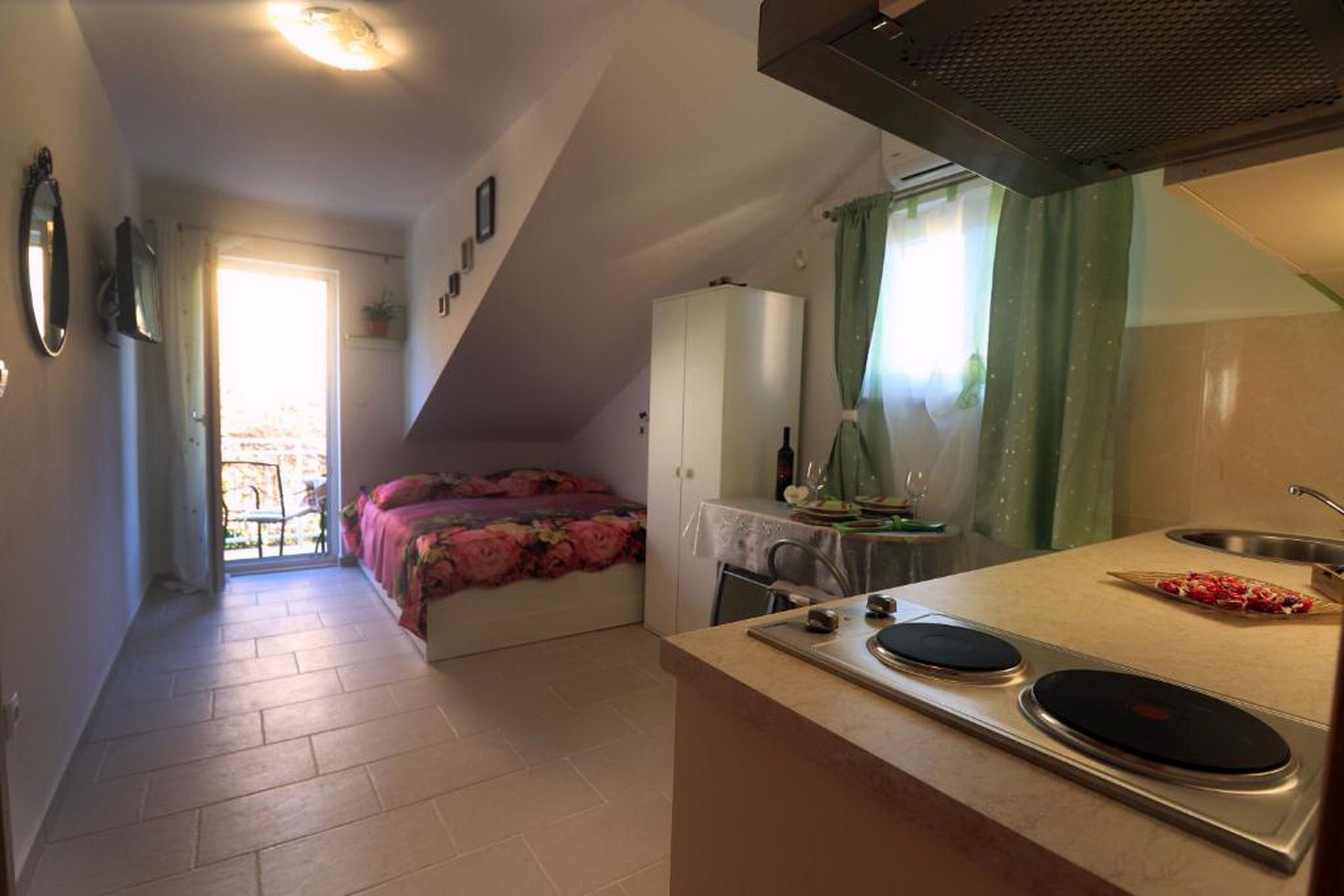 A compact kitchen with a stove, sink, and a small dining area.