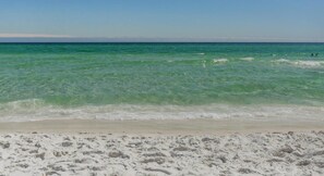 Une plage à l’eau turquoise et limpide et au sable blanc.