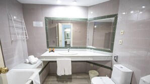 A bathroom with a bathtub, toilet, and sink.