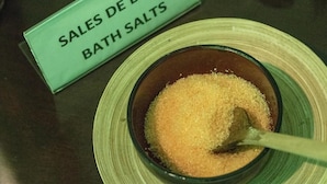 A bowl of bath salts with a spoon, and a sign that reads "SALES DE BAÑO BATH SALTS". - Junior Suite Solarium (Mairena del Aljarafe)