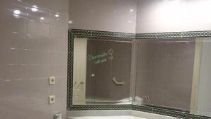A bathroom with a white sink, a toilet, and a mirror with a decorative border. - Junior Suite Solarium (Mairena del Aljarafe)