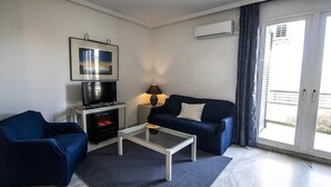 A modern living room with a sofa, a coffee table, a TV, and a fireplace. - Winter Suite       . (Mairena del Aljarafe)