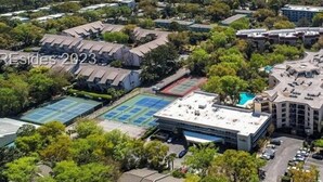 An aerial view of a residential area with multiple buildings, a swimming pool, and a view of the ocean. - Charming Beach Escape! Steps from the Beach (Hilton Head Island)