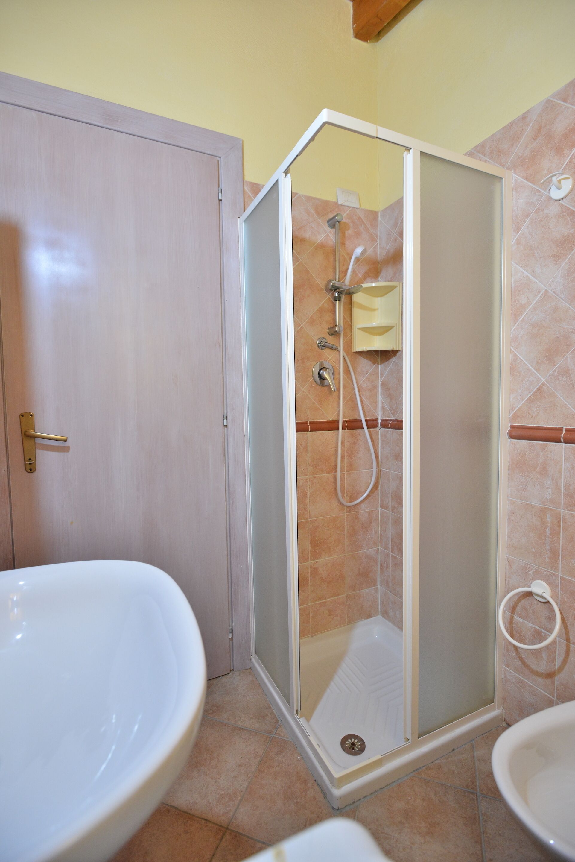 Un baño con cabina de ducha, lavabo e inodoro.