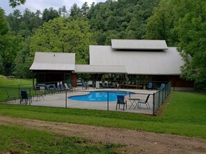 A pool area with lounge chairs and a covered deck. - Mountain Cabin, Great Decks, WiFi, Pool Table, Ping Pong Table, & Foosball (Ferguson)