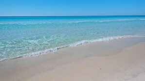 A beach with clear turquoise water and a sandy shore.
