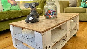 A rustic wooden coffee table with a glass jar of colorful candies.