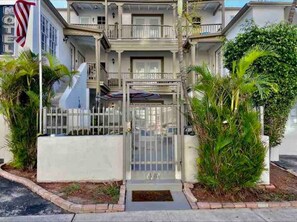 Stately two-story building with a gated entrance and beautifully manicured grounds.