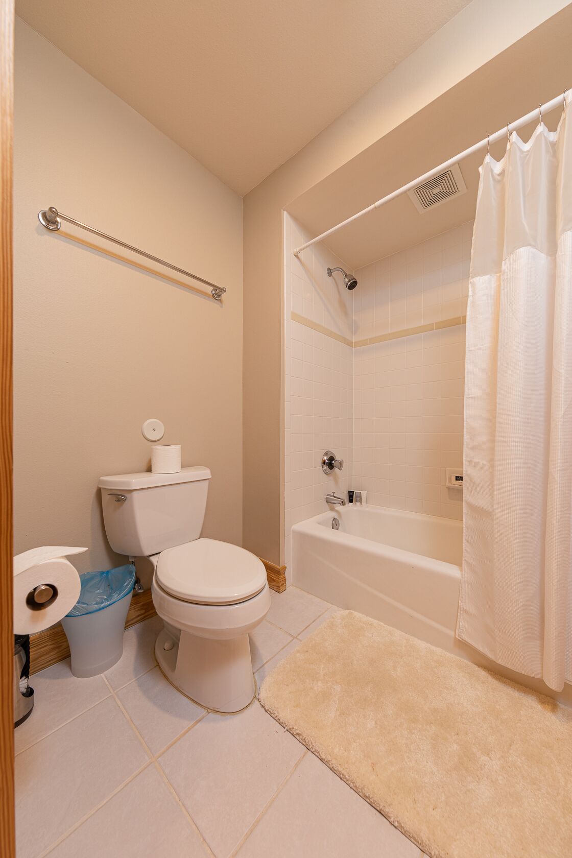 Een badkamer met toilet, douche en bad.