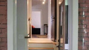 Una escalera conduce a una habitación con una pared de ladrillo y una puerta.