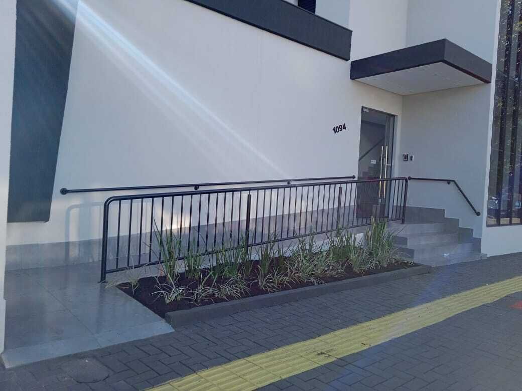 Un edificio moderno con fachada blanca, barandilla negra y el número 1094 en la pared.