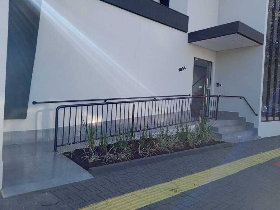 Un edificio moderno con fachada blanca, barandilla negra y el número 1094 en la pared.