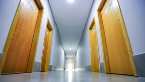 A long, narrow hallway with wooden doors on both sides, numbered 214 and 215.