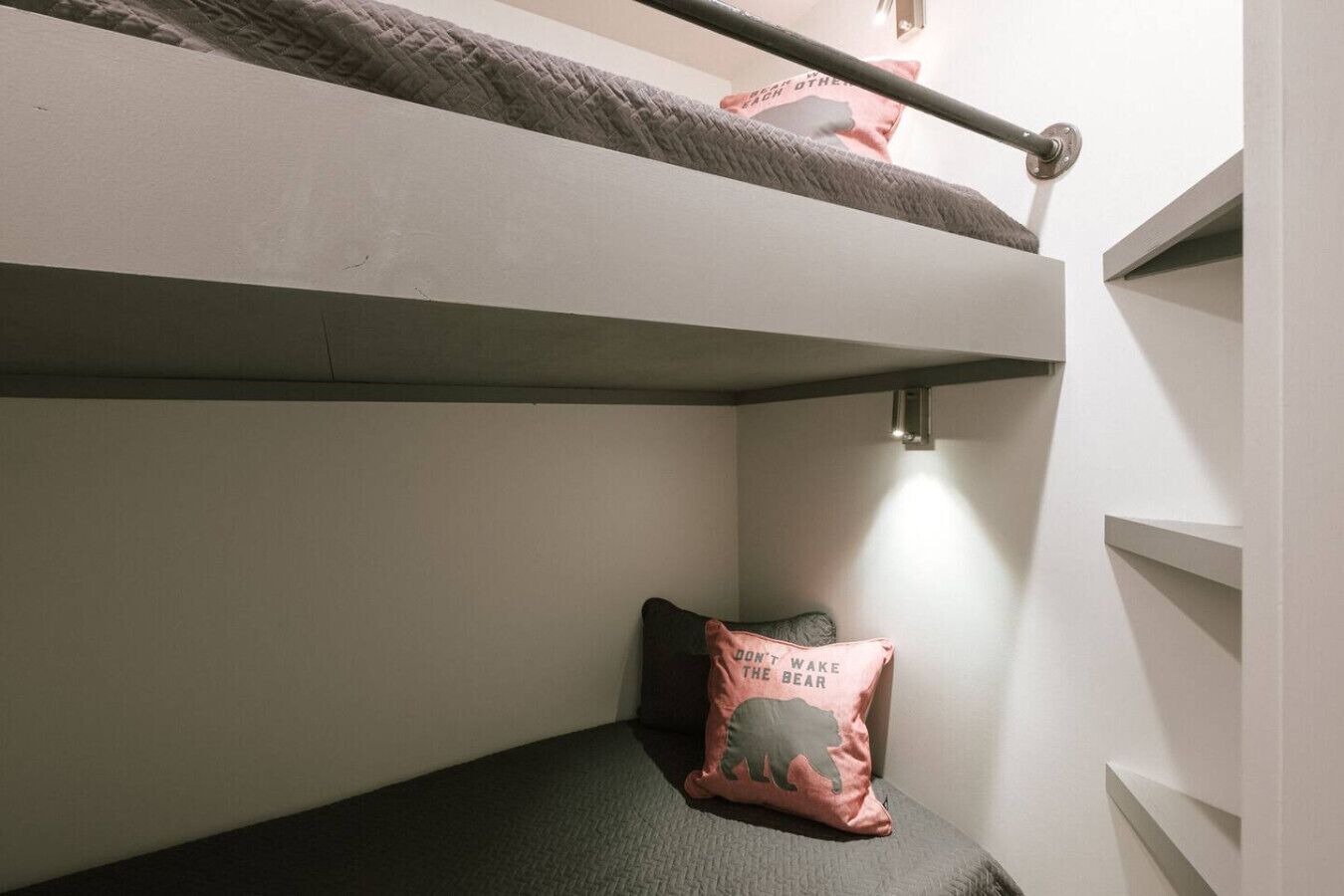 Una cama litera con un almohadón en la cama inferior.