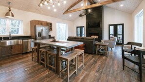A spacious kitchen with a central island, wooden beams, and a large fireplace. - Honeysuckle Bridge- Hot Tub, Firepit, Private Hiking, Sandstone Arch (Campton)