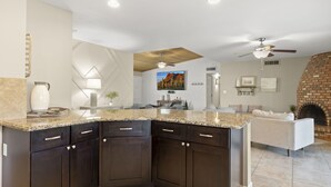 Eine moderne Küche mit dunklen Schränken, Granit Arbeitsplatten und einem eingebauten Backofen.