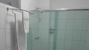 Une salle de bain avec douche, toilettes et lavabo.