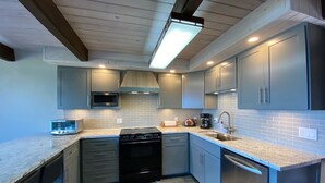 A modern kitchen with grey cabinets, a microwave, a stove, and a dishwasher. - Beautiful Ocean View & path to the beach (Newport)