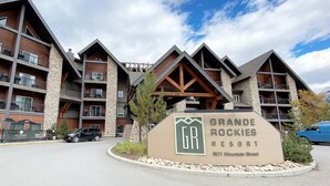 Un immeuble à plusieurs étages, avec une enseigne indiquant « GRANDE ROCKIES RESORT » à l’entrée.