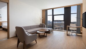 Una sala de estar moderna con un sofá modular, una mesita redonda y un televisor.
