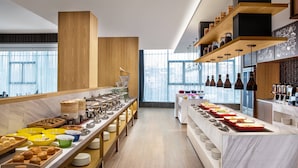 Una cocina moderna con una encimera larga que exhibe diversos alimentos y utensilios.