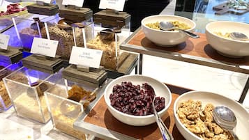 A buffet with various food items including rice, corn flakes, granola, and nuts.