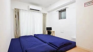 Cozy retreat with a bed, table, and window, perfect for a relaxing stay.