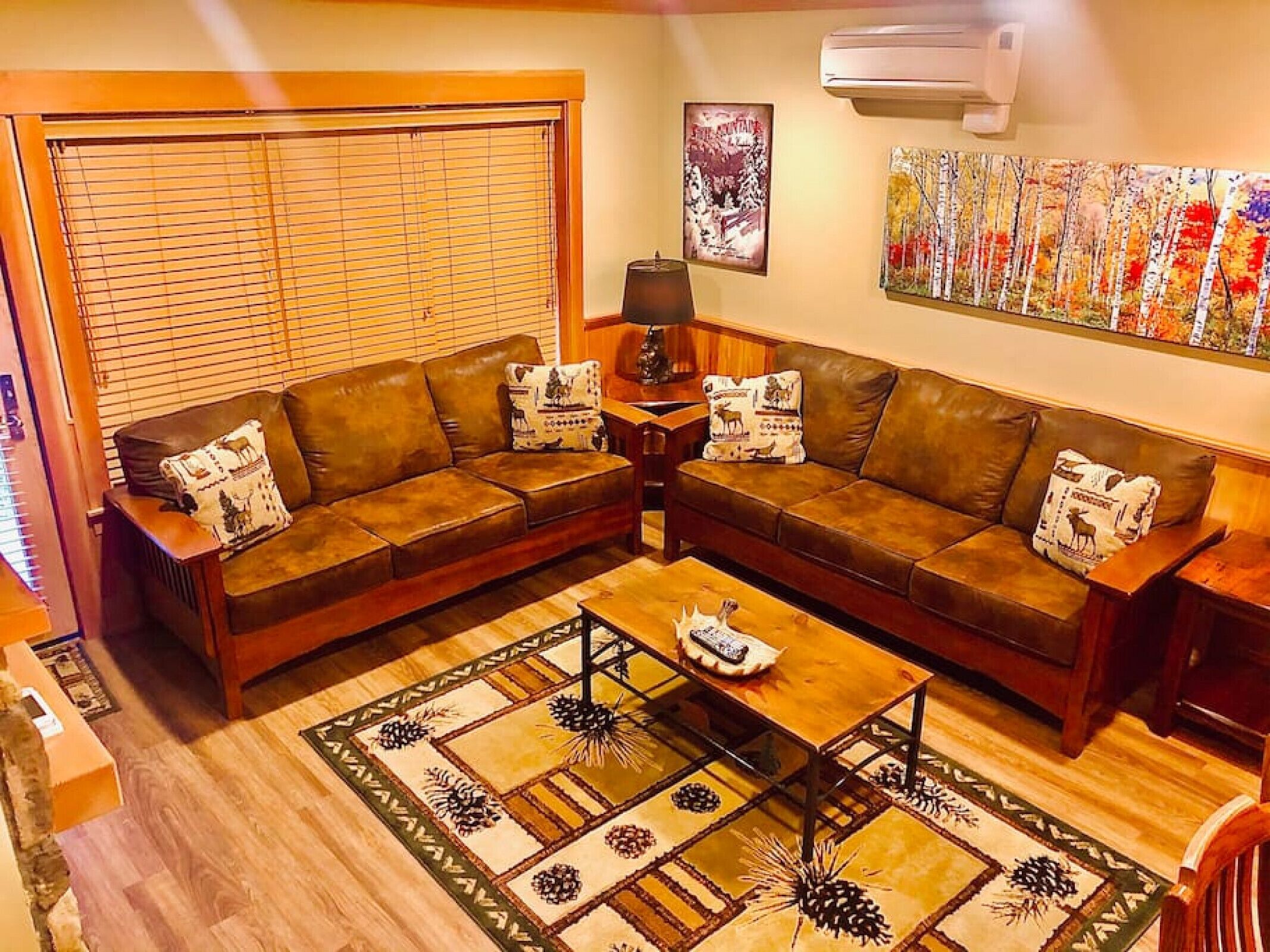 Ein Wohnzimmer mit einem Ecksofa, einem Couchtisch und einem gemusterten Teppich.