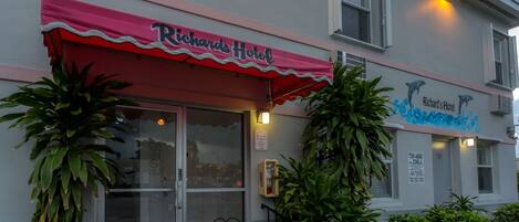 Hotel Richard, con toldo rojo, puerta de entrada de vidrio y señalización de zona de remolque.