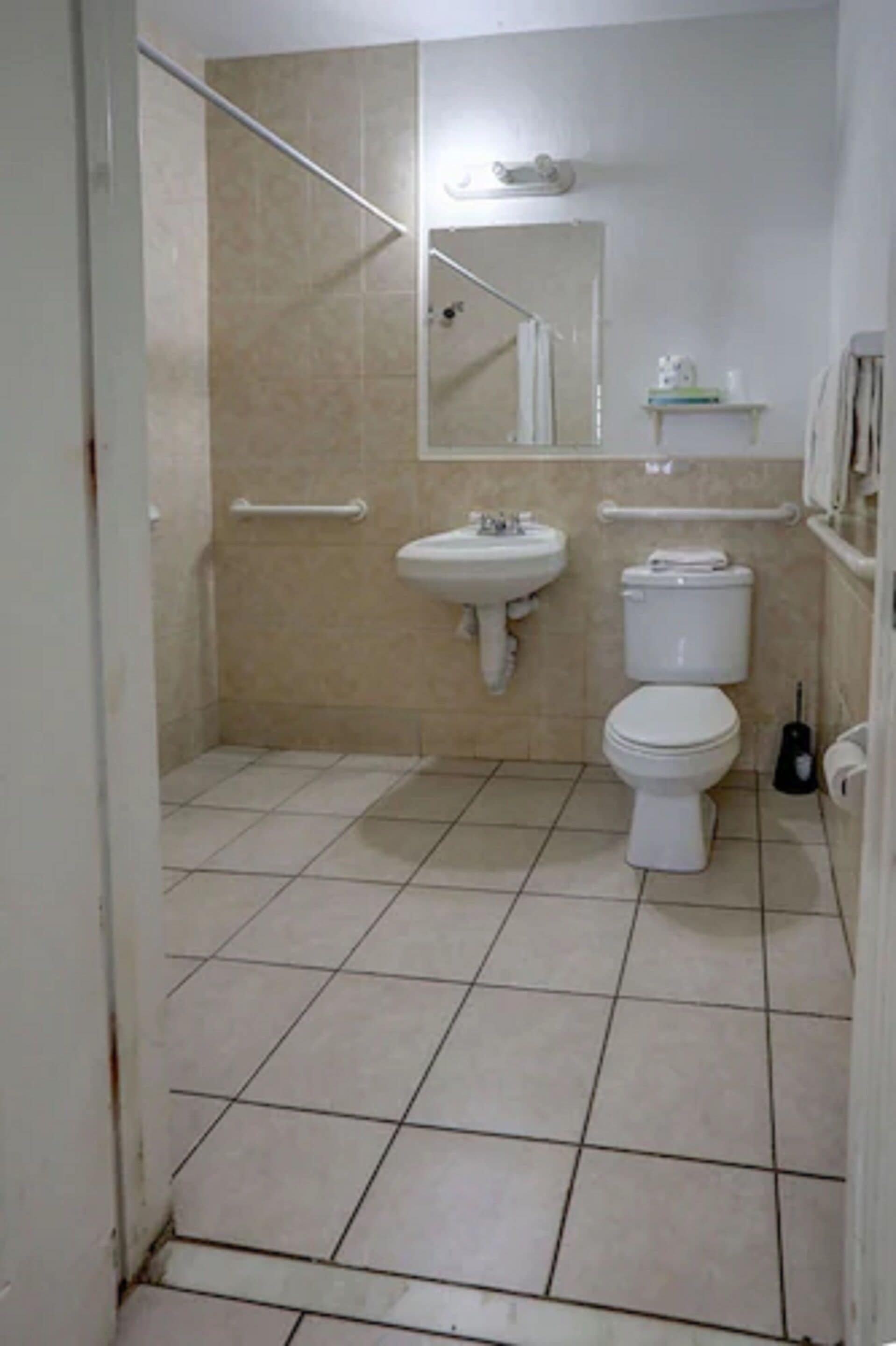A bathroom with a toilet, sink, and shower area.