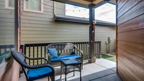 A covered porch with wicker furniture and a small table, a window, and a string of lights. - 4 bed, 4 bath, Minutes to Downtown Denver (Denver)