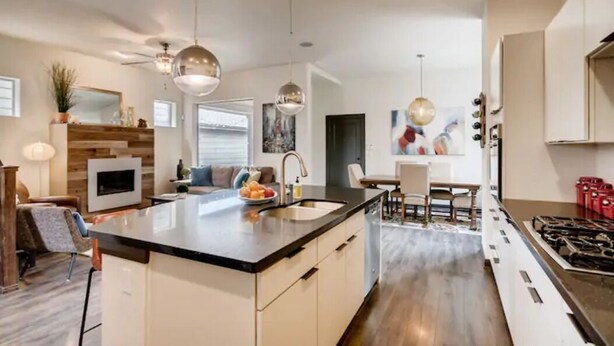 A modern kitchen with a central island, pendant lighting, and a dining area with a table and chairs. - 4 bed, 4 bath, Minutes to Downtown Denver (Denver)