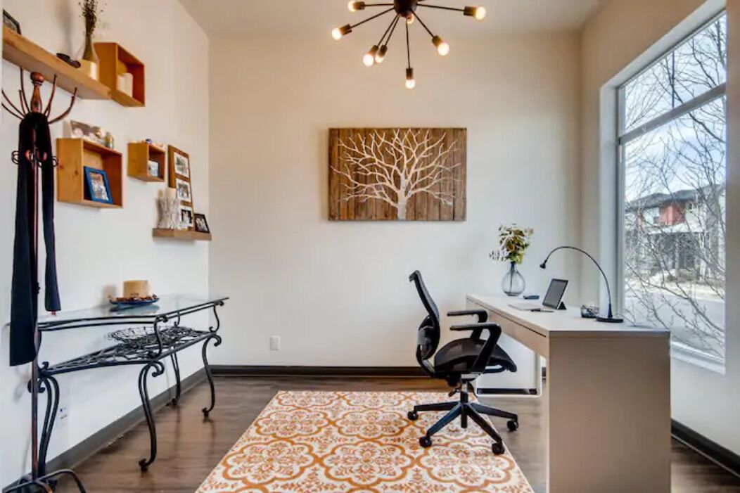 Un espace de bureau moderne comprenant un bureau, une chaise et une grande fenêtre.