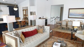 A spacious living room with a large sofa, a coffee table, and a dining area with chairs. - New! Luxury Mountain Escape in Majestic Playground (Tetonia)