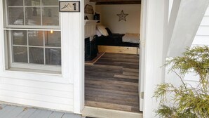 Una habitación con una cama de madera, decoración con estrellas y una ventana con el número siete.