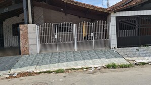A residential building with a gated entrance, tiled roof, and a visible satellite dish. - 800 mts da Praia (SP)