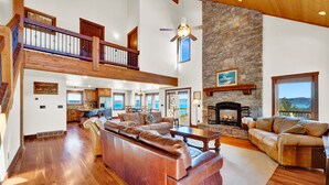 A spacious living area with a large leather sofa, a fireplace, and a stone accent wall.
