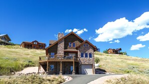 A large, two-story house with a stone facade, a balcony, and a garage.