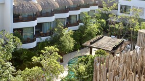 A resort with multiple balconies, a pool, and lush greenery. - Aluna Resort Tulum (Tulum)