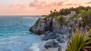 A coastal landscape with a rocky shoreline, beach, and vegetation. - Aluna Resort Tulum (Tulum)