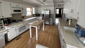 A kitchen with white cabinets, a wooden table, a stainless steel refrigerator, and a microwave. - 7br/3.5ba Classic Bay Head Beach House Steps To The Beach  (Bay Head)