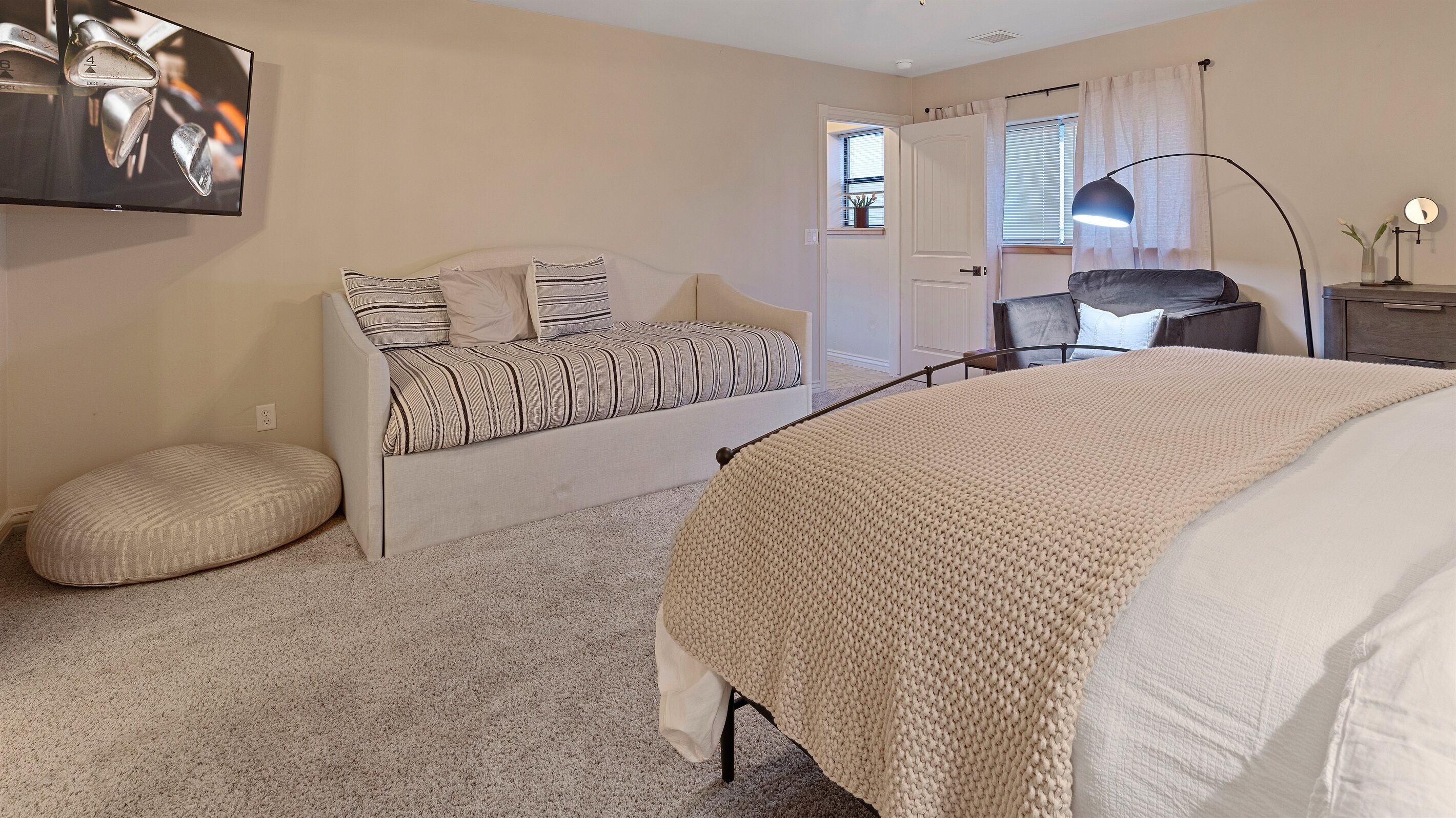 A bedroom with a bed, a sofa, a desk, and a chair.