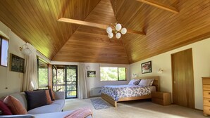 Ein Schlafzimmer mit Bett, Sofa, Schminktisch und Deckenventilator.