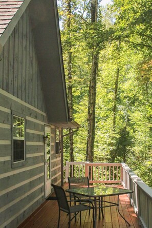 A wooden cabin with a deck, a table, and chairs. - ‘Firefly Cove’ - 3 Mi to Parkway & National Park! (Sevierville)