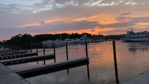 A marina with docked boats and a large ferry at sunset.