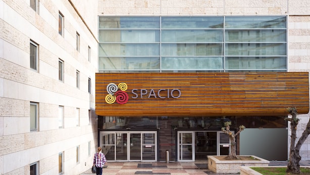 Ein Gebäude mit einem Schild mit der Aufschrift 'SPACIO' und einem modernen architektonischen Design.